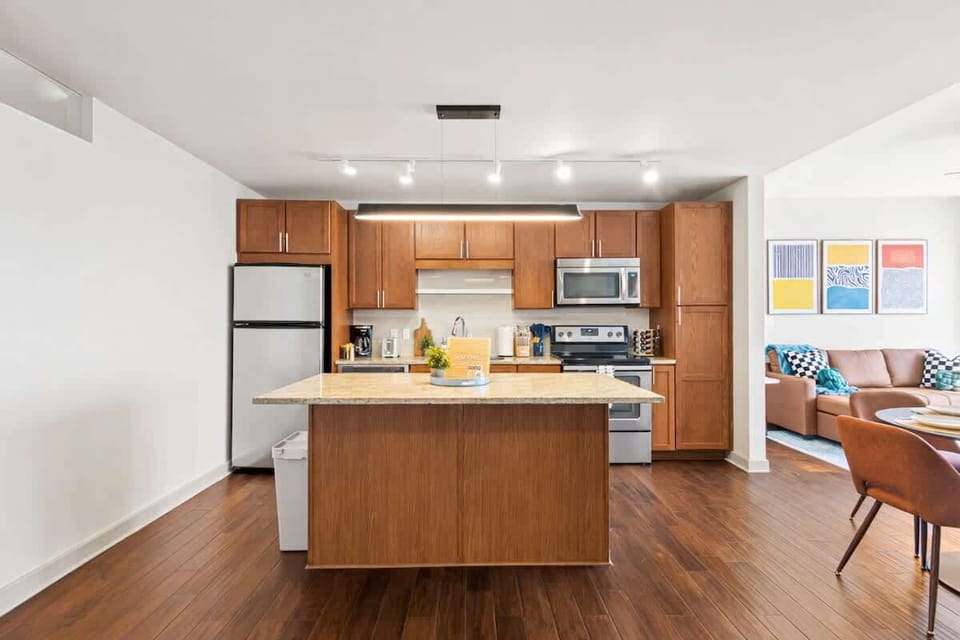 Modern open kitchen with a central island, full appliances, and a bright dining area for cooking and enjoying meals.