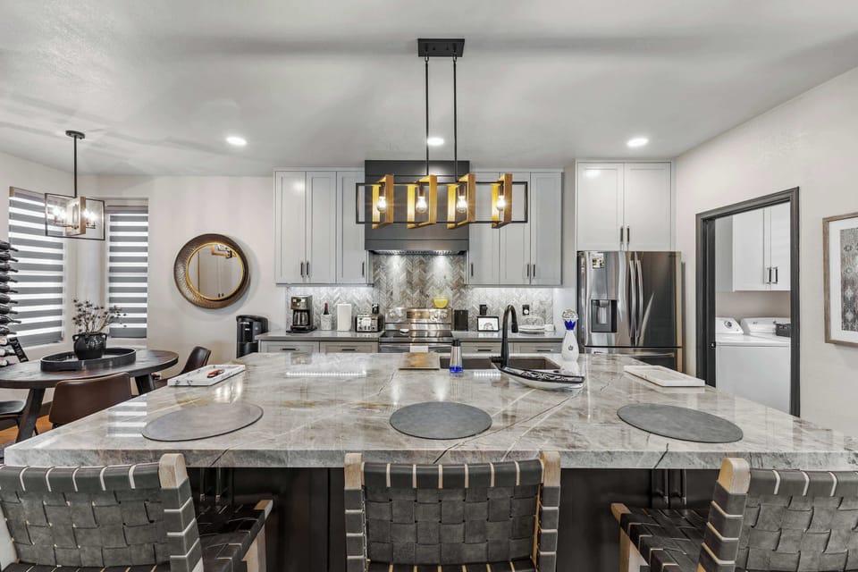 Gather in this beautifully updated chef-inspired kitchen, featuring a stunning oversized island, sleek stainless appliances, and stylish bar seating.