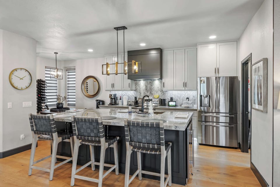 Gather in this beautifully updated chef-inspired kitchen, featuring a stunning oversized island, sleek stainless appliances, and stylish bar seating.