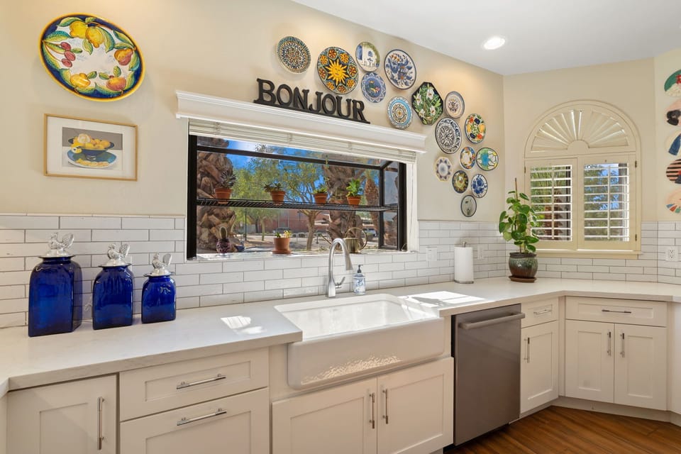 Bright chef’s kitchen with a Wolf range, bold tile backsplash, spacious island with seating, and generous counter space for effortless meals.