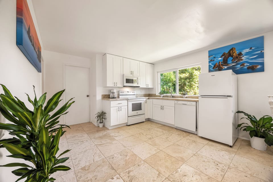 Open and airy kitchen with full-size appliances, natural light, and modern coastal finishes.