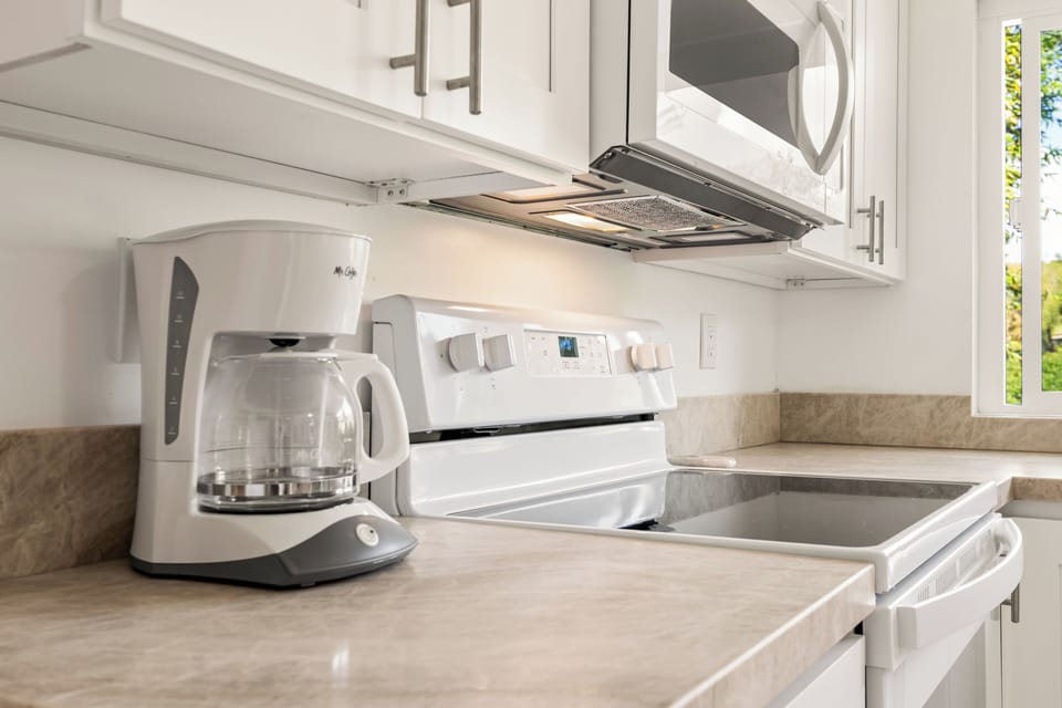 Fully stocked kitchen countertop with coffee maker, microwave, and everything needed for a comfortable stay.