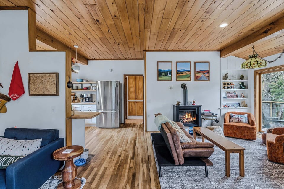 Open-concept living, dining, and kitchen with vaulted wood ceiling