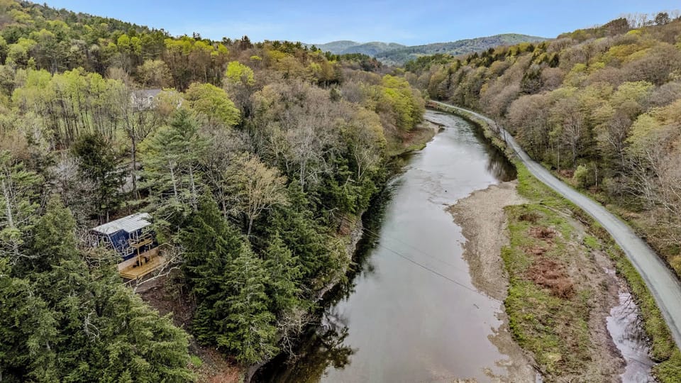 Cottage perched above the river among evergreens