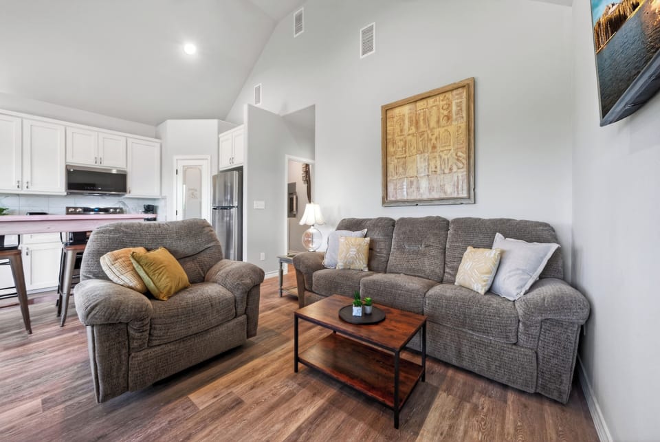 Bright open-concept living and dining area with vaulted ceilings and easy access to the balcony.