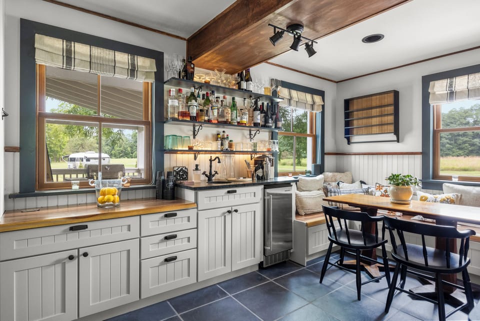 Bright, updated kitchen area with white cabinetry, butcher block countertops, and a built-in wine cooler.