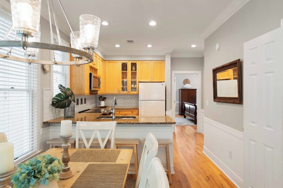 Gourmet kitchen featuring warm wood cabinetry, a breakfast bar, and open sight lines to the dining area.