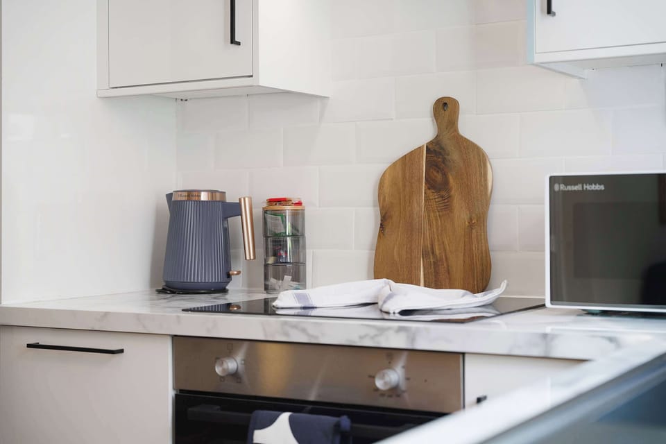 Modern appliances and useful preparation space make this kitchen well suited to both short and extended stays. The integrated hob, countertop appliances, and practical storage support easy everyday cooking and meal preparation.