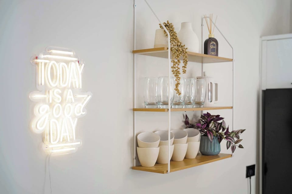 Subtle decorative touches and open shelving add character to this dining area, creating a welcoming setting for shared meals. The practical layout connects seamlessly with the kitchen, making everyday dining feel easy and comfortable.