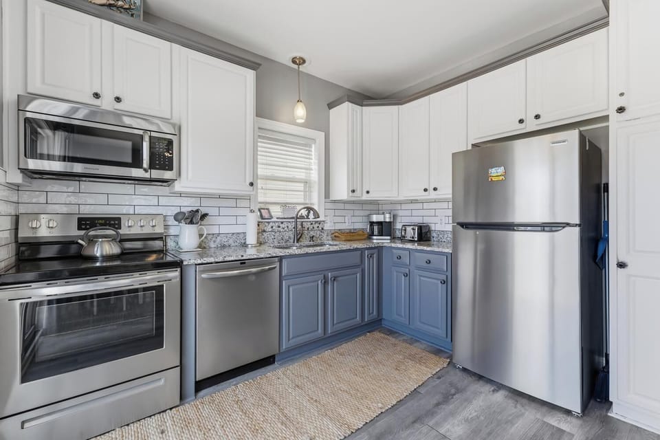 Cook your favorite meals in this bright, fully-equipped kitchen with modern stainless steel appliances, granite countertops, and all the essentials you need to feel at home.