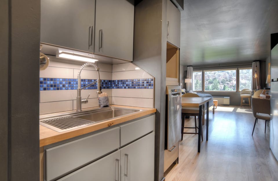 Small kitchen area with full-sized fridge, stove, oven and dish washer.