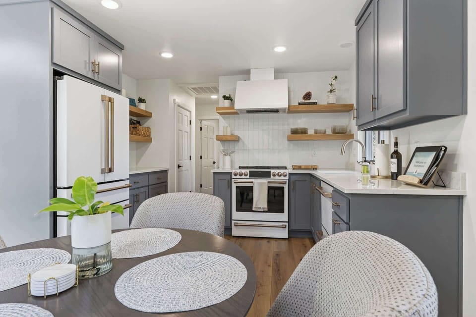 Enjoy preparing meals in your fully equipped kitchen with sleek gray cabinetry, modern stainless appliances, a gas range, and open shelving that adds warmth to your stay.