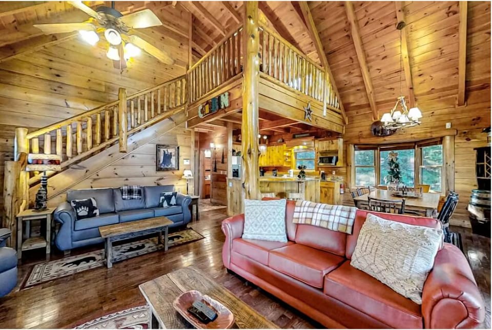 Unwind in your cozy log cabin retreat with vaulted ceilings, leather sofas, and rustic charm creating the perfect mountain getaway.