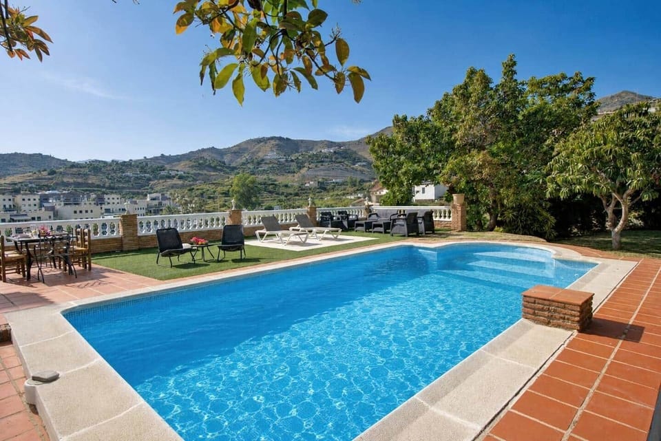 Piscina junto al jardín y zona de comedor exterior