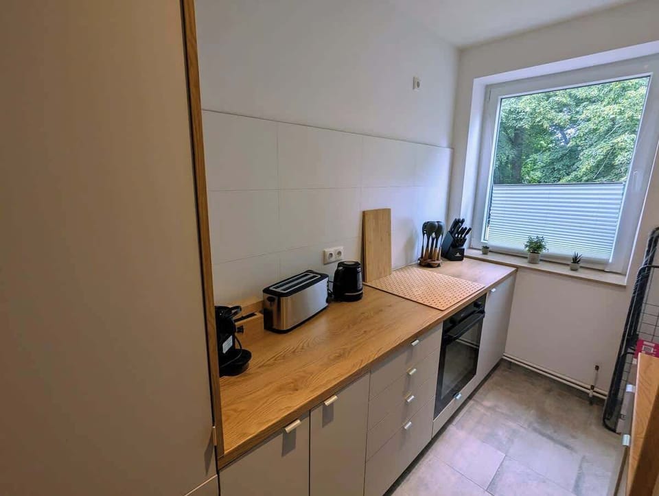 Küchenzeile mit Arbeitsplatte aus Eiche, Toaster, Wasserkocher und Backofen.