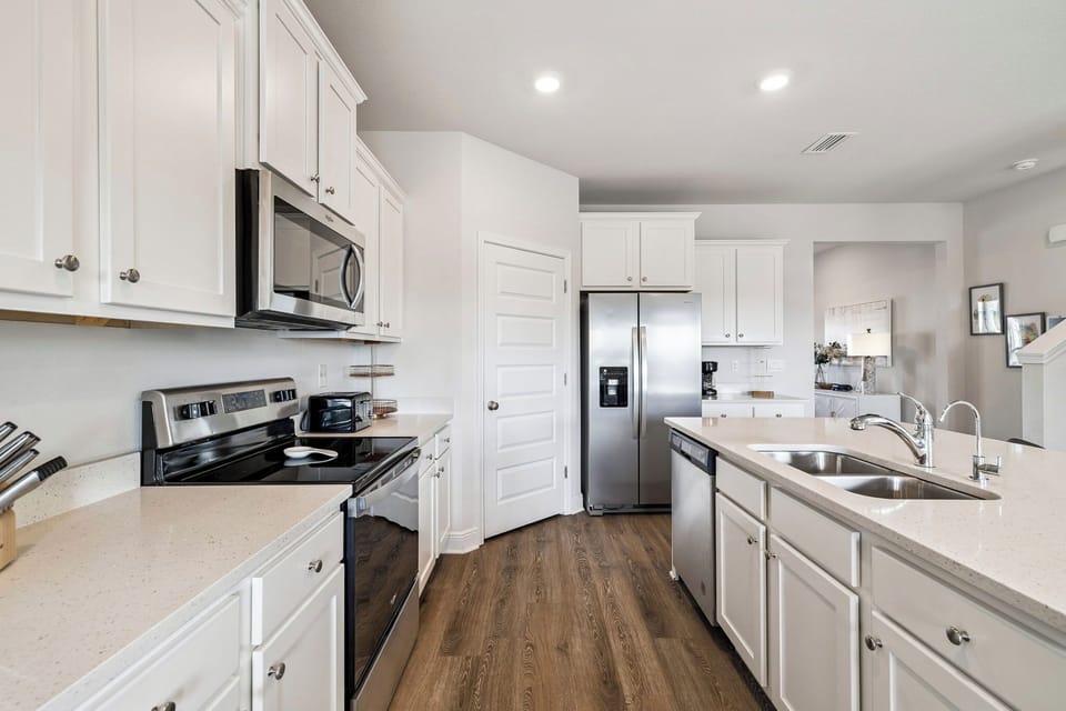 Your pristine white kitchen awaits with modern stainless appliances, spacious counters for meal prep, and everything you need for home-cooked comfort.