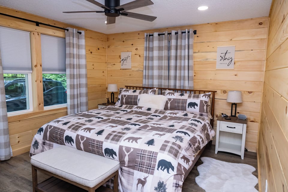 The front bedroom has a plush king bed, soft linens, and enviable cabin charm