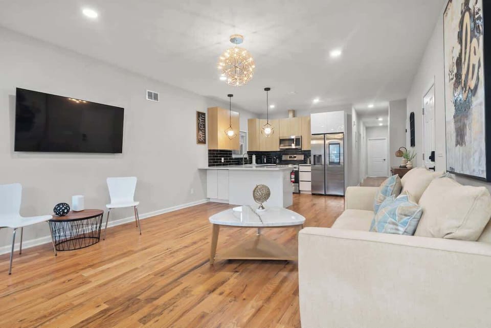 Open living area flowing into the fully equipped kitchen—perfect for group stays, movie nights, and home-cooked meals.