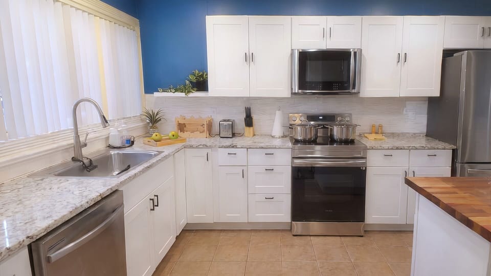 Fully equipped kitchen with modern appliances and a cookware.