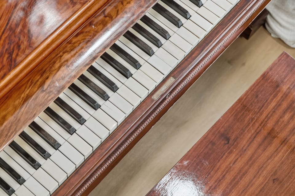 Antique piano by the window — relax and play while enjoying peaceful lake views.