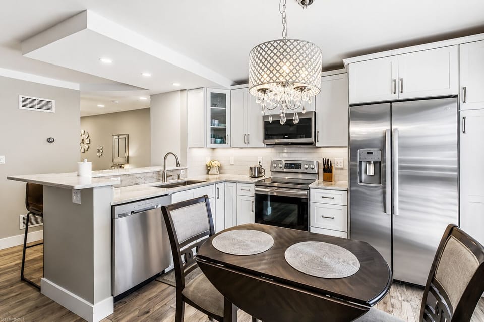 Full kitchen with stainless appliances, chandelier island, and a Keurig.