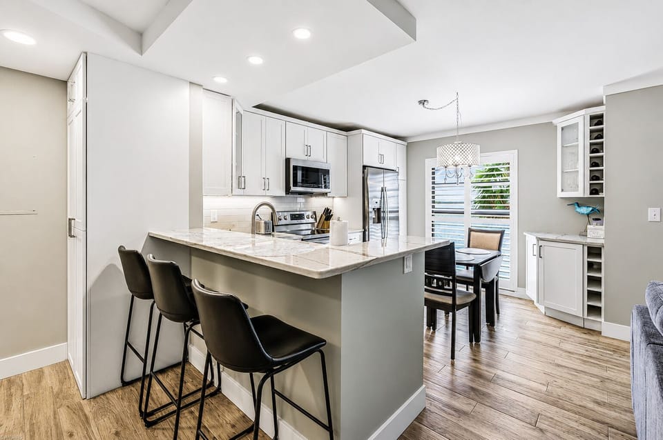 Bar stools, marble quartz peninsula, ice maker fridge. Happy hour.