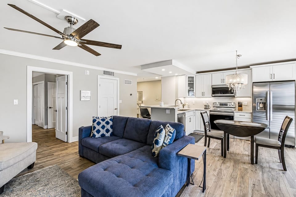 Living room to kitchen to lanai — connected, open, and facing the water.