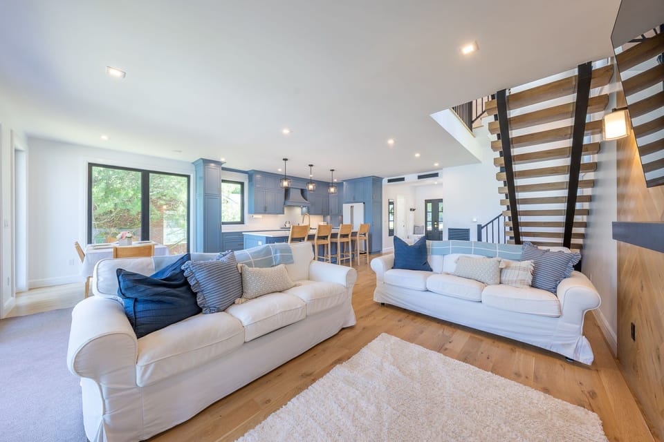 Designer living room with modern furnishings, and waterfront views.