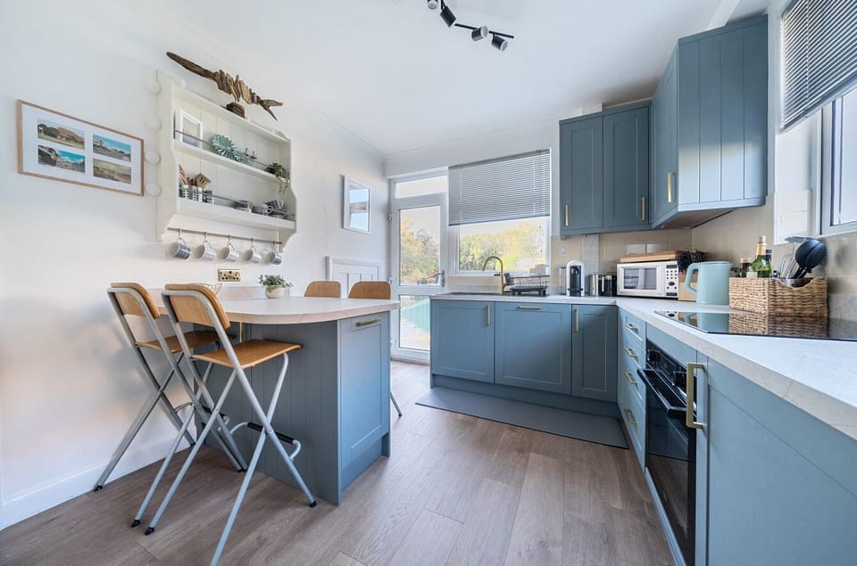 Modern kitchen at the rear of the house with a door out to the part lawn / part patio rear garden.