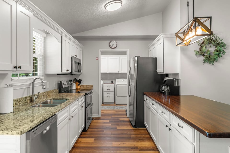 Fully stocked kitchen with updated stainless steel appliances.