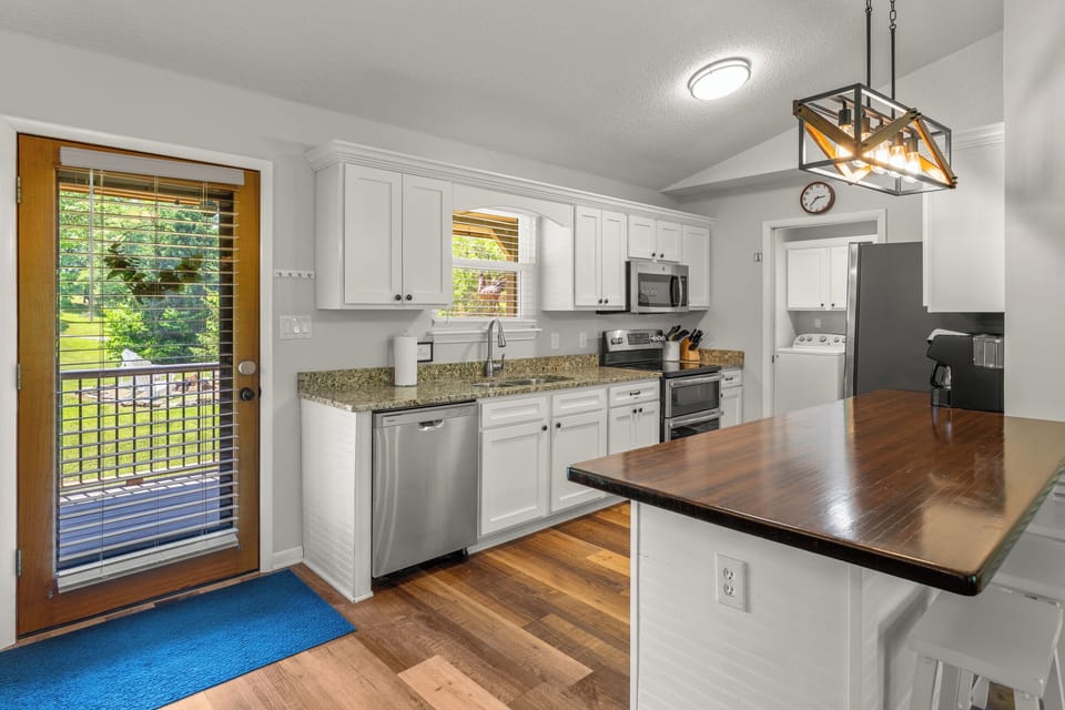 Fully stocked kitchen with updated stainless steel appliances.