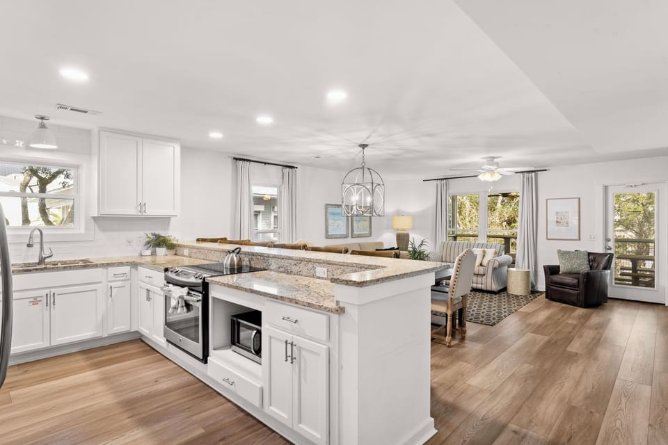 A chef’s delight featuring modern stainless steel appliances, crisp white cabinetry, and a beautiful central island.