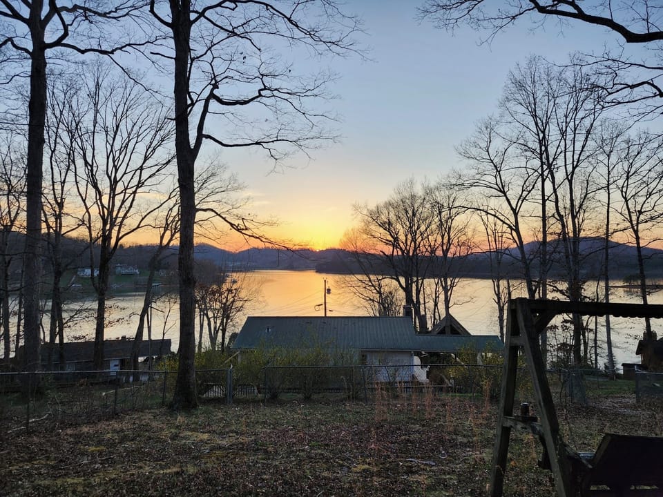 Sunset from fenced yard overlooking cottage.