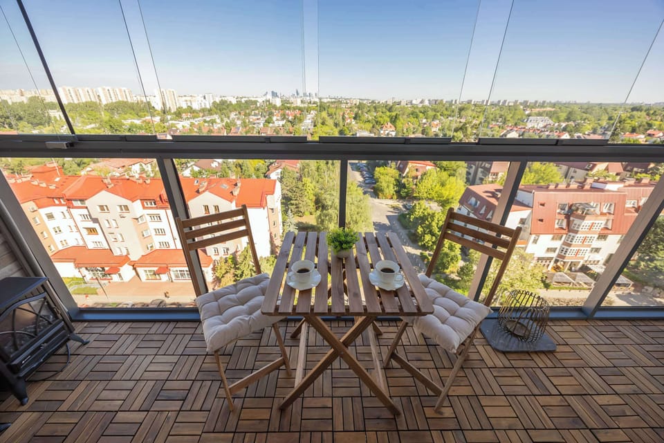 A balcony with outdoor seating and a panoramic view of the surrounding city. The elevated position offers an impressive outlook.