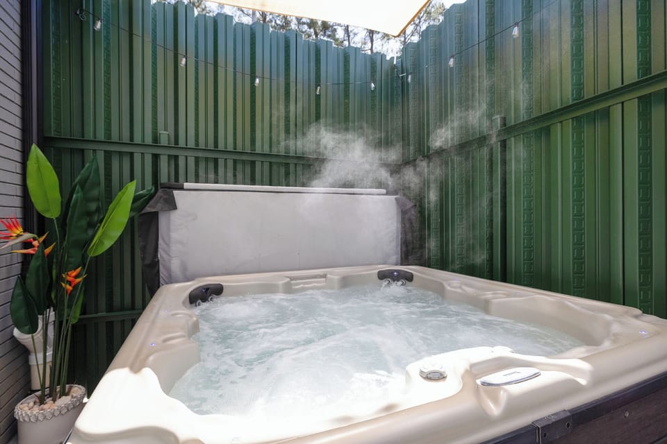 Private, steamy hot tub oasis with shade sail and string lights