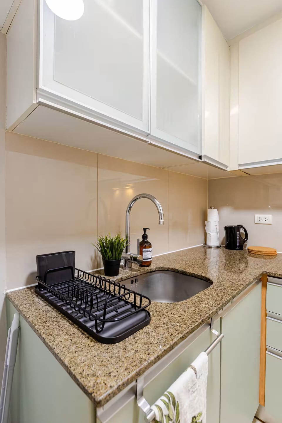 Complete and fully equipped kitchen with fresh dish towels, organized cookware.
