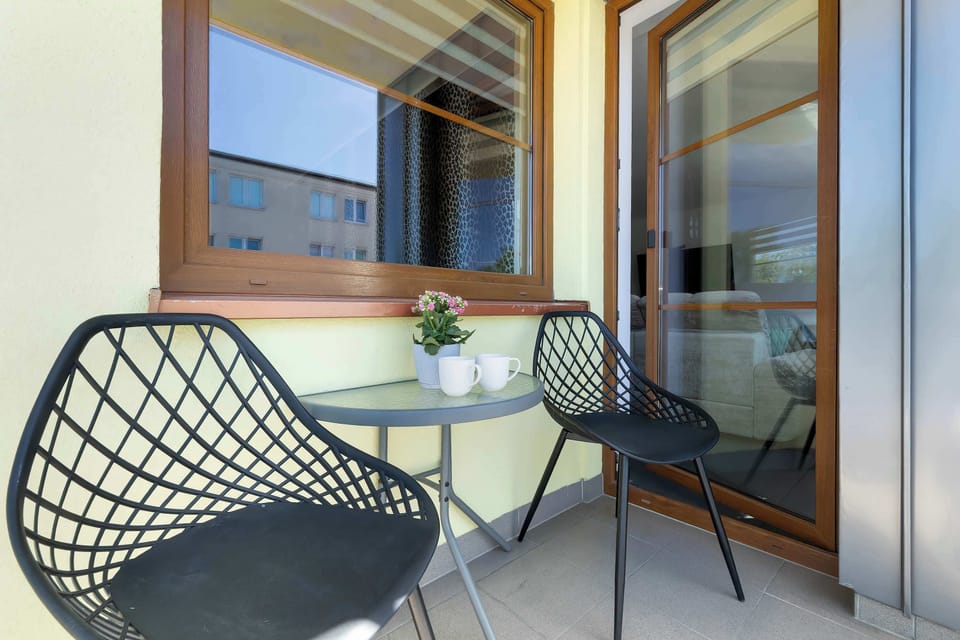 Cozy balcony seating area with glass railing and city views