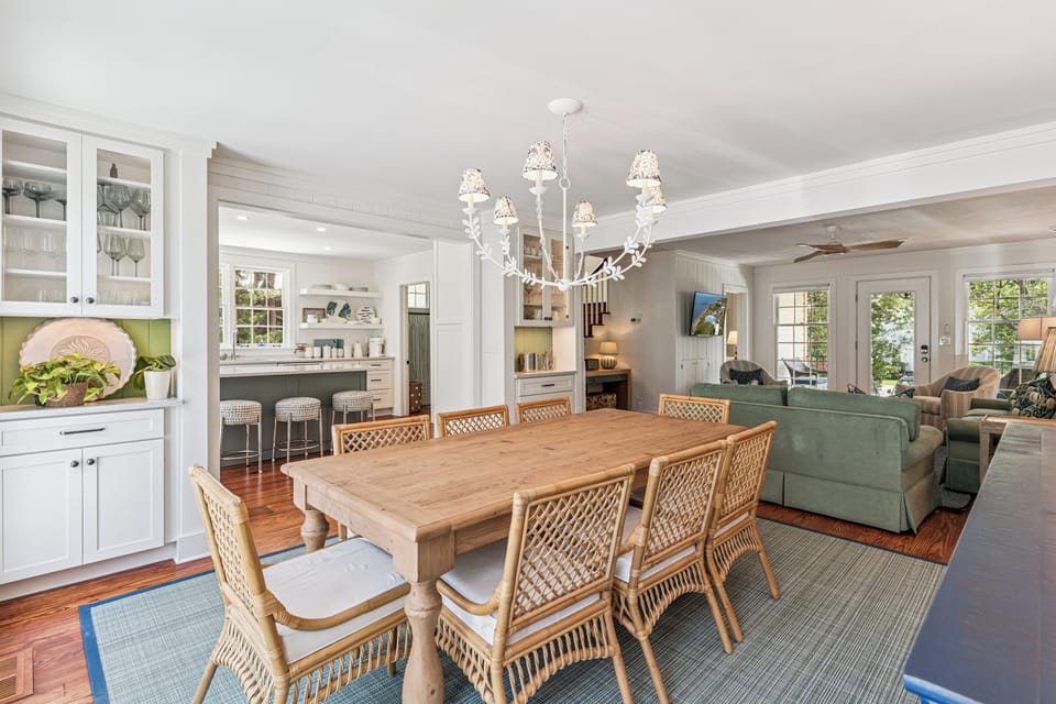 This charming open-concept living space blends coastal elegance with homey comfort. Picture yourself gathered around the farmhouse table for breakfast or unwinding in the cozy living area after a day of exploring.