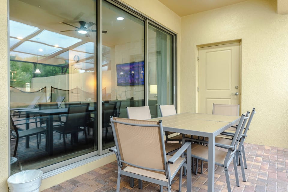 Enjoy outdoor meals in the covered patio area, featuring a spacious dining table with seating for six. Conveniently located beside the living room and pool, it is a comfortable spot for breakfast, lunch, or dinner together.
