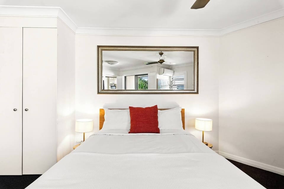Rest comfortably in the sleeping area, where the queen bed and simple styling create a calm space to unwind after a day exploring the city.