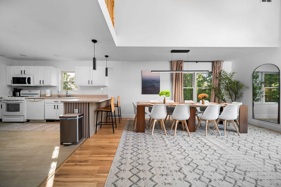 Bright kitchen and dining space with high ceilings and seating for a group.