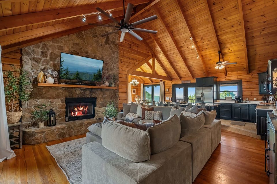 Sink into the sectional beneath soaring beams, with the fireplace on one side and the mountains on the other.