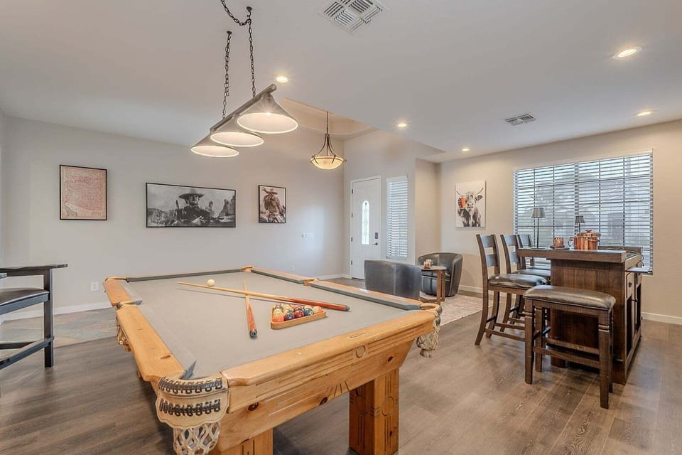 Game room with pool table has bar seating for cheering for the pool sharks.