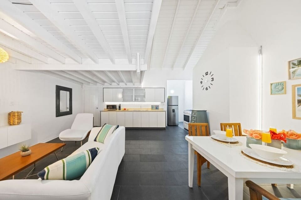 Relax in a bright, airy living area with modern decor, inviting seating, cool A/C, and an easy flow into the sleek kitchen.