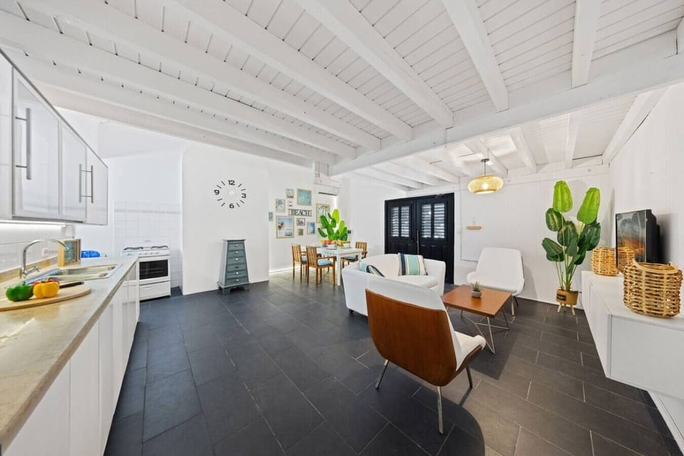 Bright and inviting living room with modern decor, tropical touches, cozy seating, and cool A/C for relaxing after a fun day exploring the island.