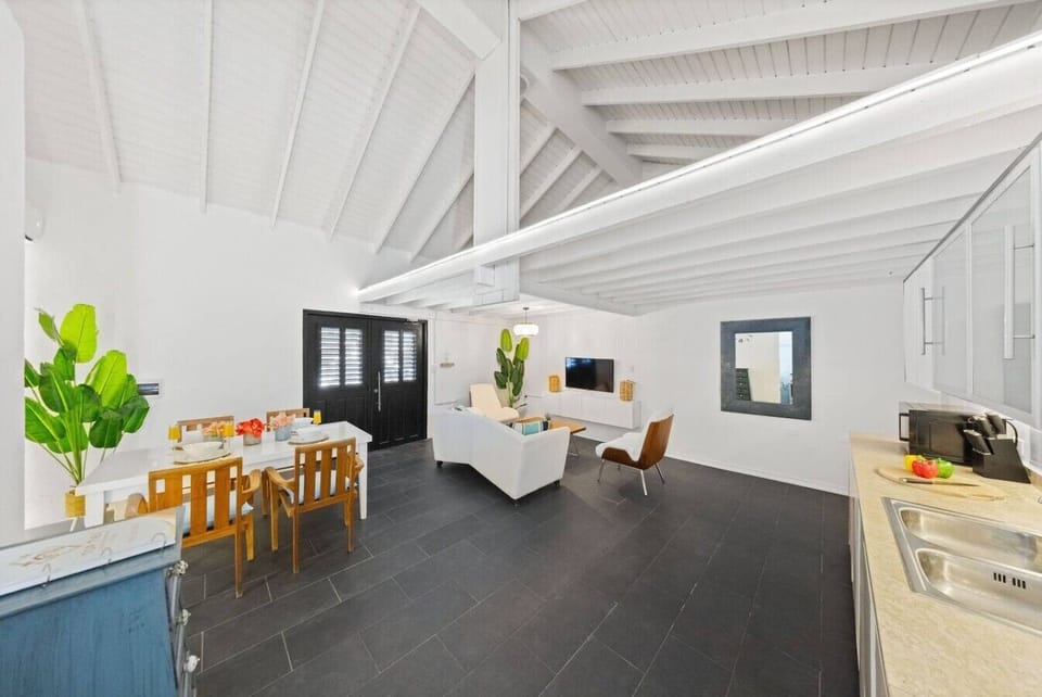 Gather in a sunlit dining and living area with sleek furniture, vibrant decor, cool A/C, and plenty of space to relax, dine, and connect.