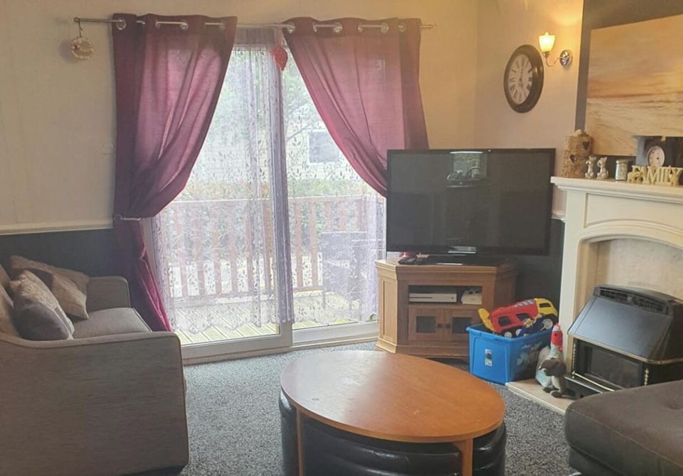Living room showing double doors to decking balcony