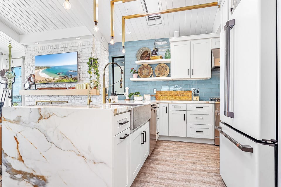 Modern kitchen with blue tile accents and space to gather after beach days
                