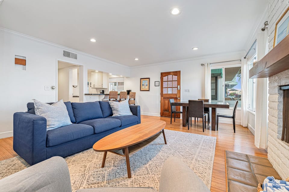 A bright, open-concept living space seamlessly connects the living room, dining area, and kitchen
                