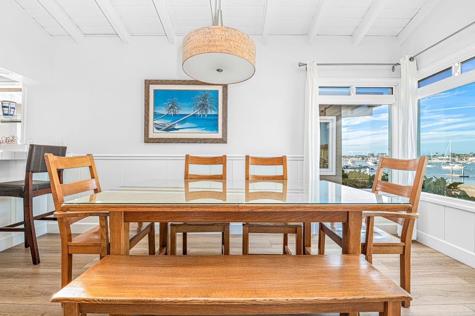 A beautifully crafted dining table for six, set beside a bay window
                